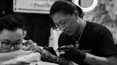 Homem exibindo tatuagens masculinas no braço e ombro feitas em estúdio no Tatuapé