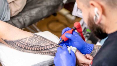 Tatuador desenhando em pele dentro de estúdio de tatuagem no Tatuapé com ambiente higienizado e moderno