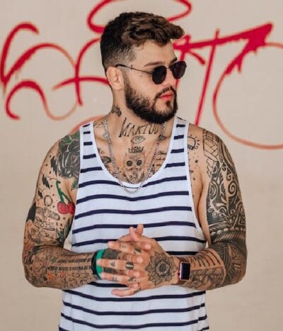 Tatuador profissional aplicando uma tatuagem detalhada em estúdio moderno no Tatuapé