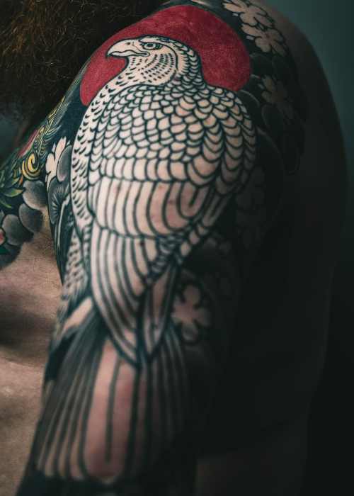 Tatuagem Masculina no Braço no Tatuapé Homem exibindo tatuagem masculina no braço em estúdio de tatuagem no Tatuapé.