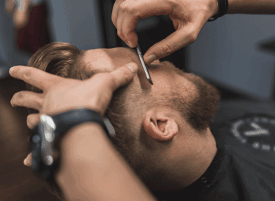 Corte de Cabelo Masculino na Art Brilho Ink – Barbearia Tatuapé Barbeiro profissional realizando corte masculino na barbearia Art Brilho Ink no Tatuapé