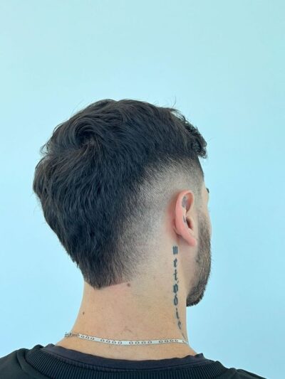 Homem com corte moicano disfarçado moderno feito em barbearia no Tatuapé.