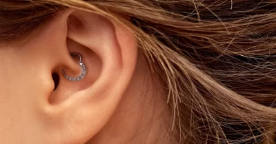 Piercing daith aplicado na orelha com joia delicada em estúdio no Tatuapé