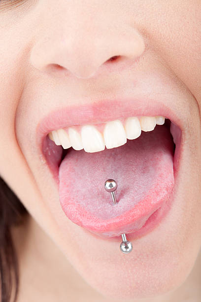 Pessoa com piercing na língua, atendimento profissional no estúdio Art Brilho Ink no Tatuapé.