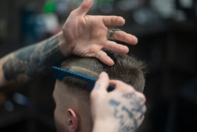 Homem moderno cortando cabelo em salão masculino no Tatuapé com estilo e atendimento personalizado.