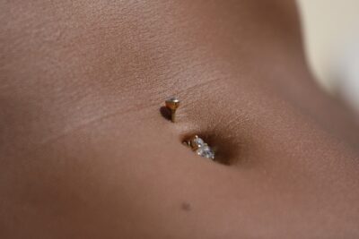 Piercing no umbigo aplicado com profissionalismo no estúdio Art Brilho Ink no Tatuapé.