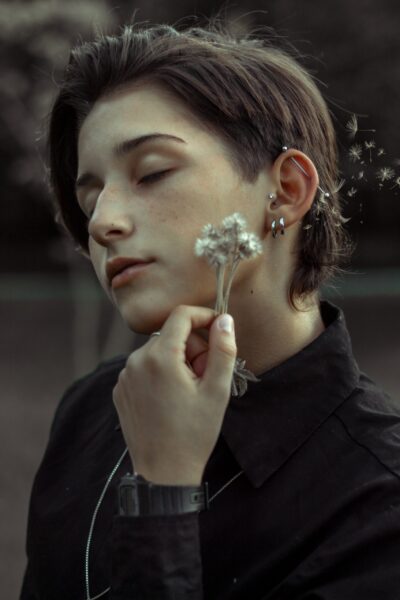 Cliente exibindo piercing transversal na orelha feito no estúdio Art Brilho Ink no Tatuapé.