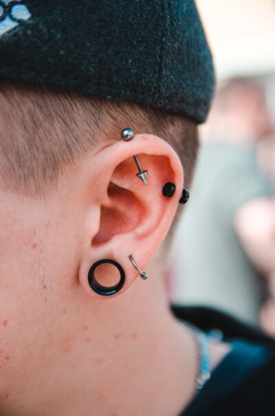 Rapaz com piercings na orelha feitos em estúdio profissional em São Paulo