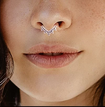 Pessoa com piercing no septo em estúdio profissional em São Paulo, com ambiente limpo e seguro.